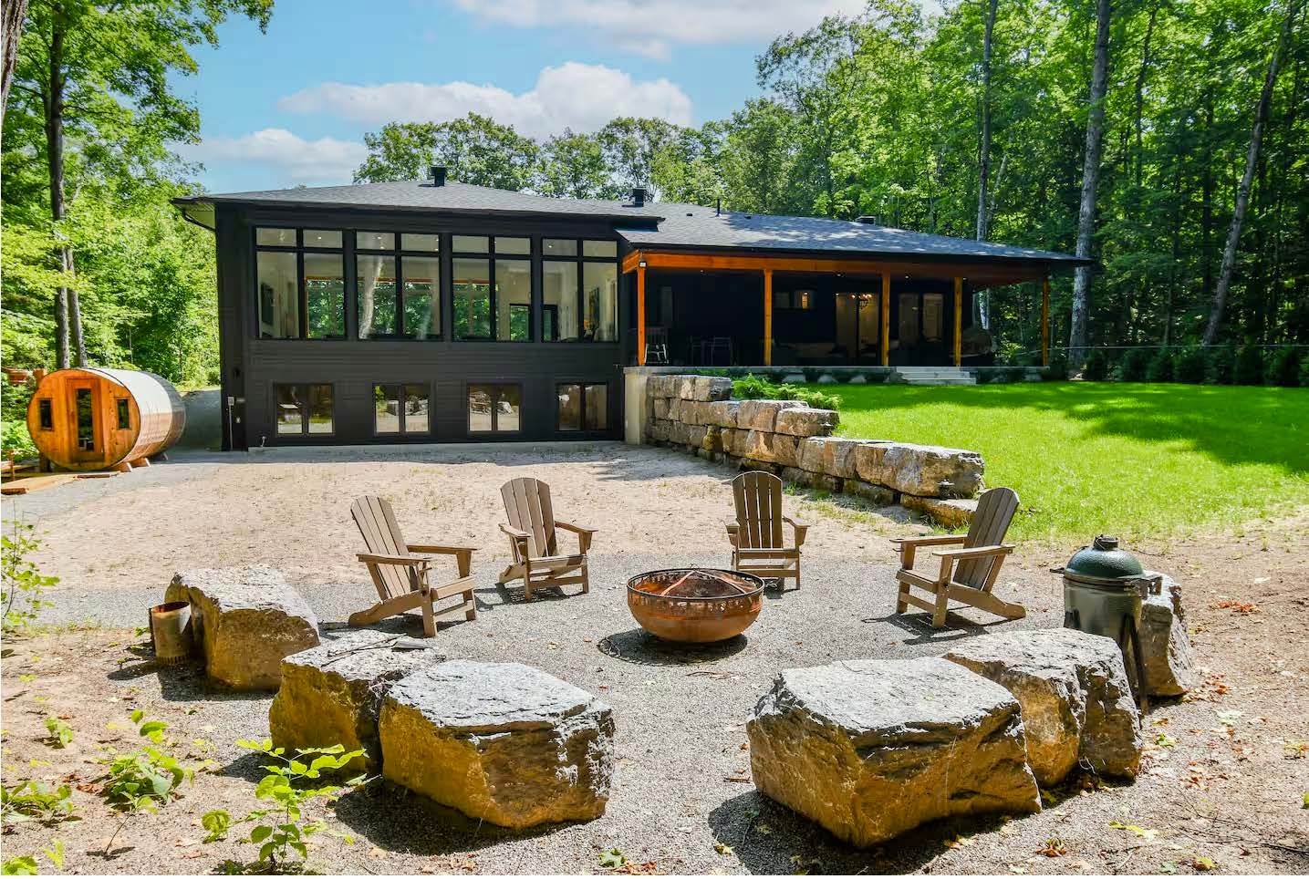 Modern cottage with fire pit seating area and barrel sauna