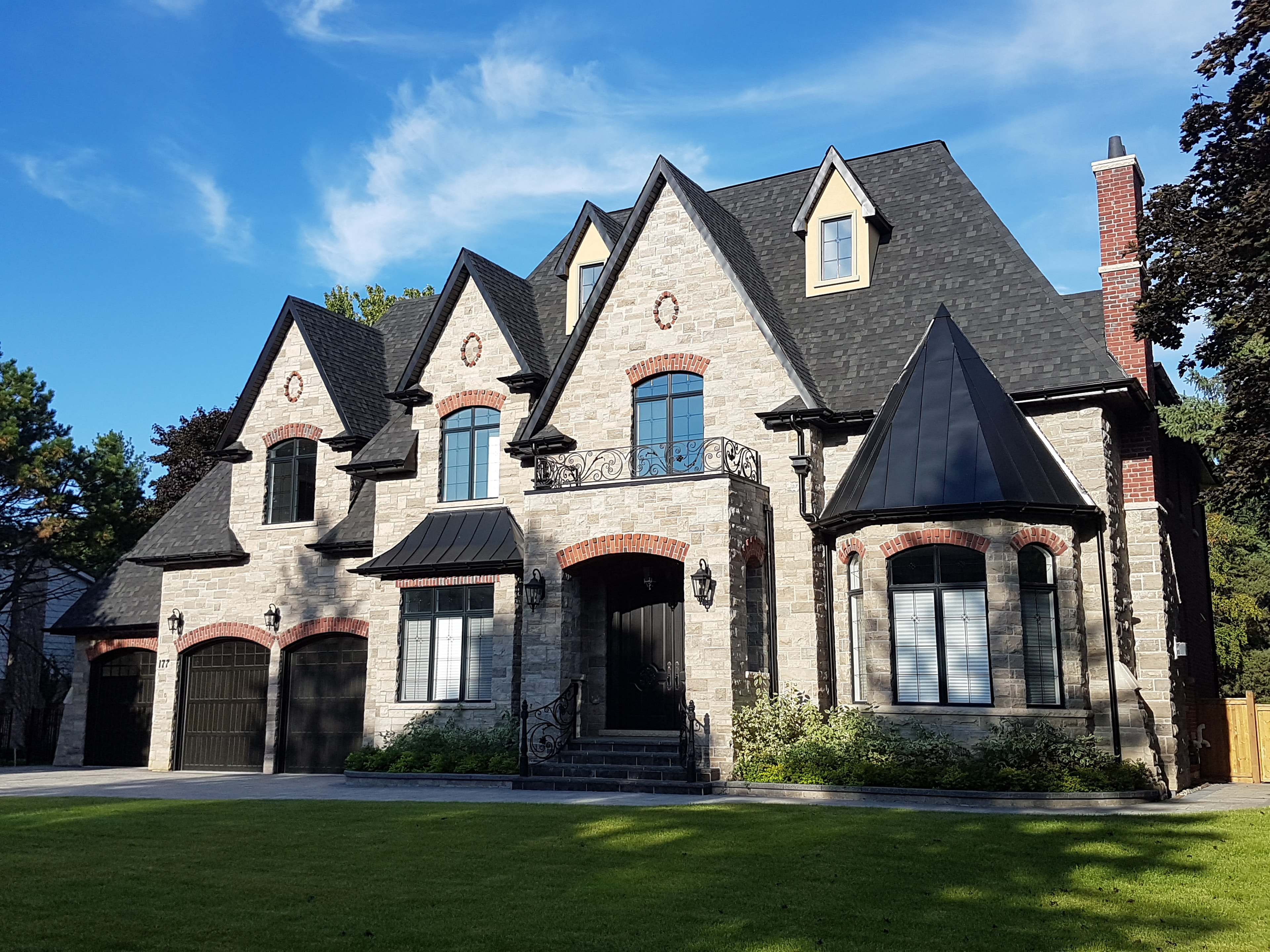 Traditional stone home with black roofing